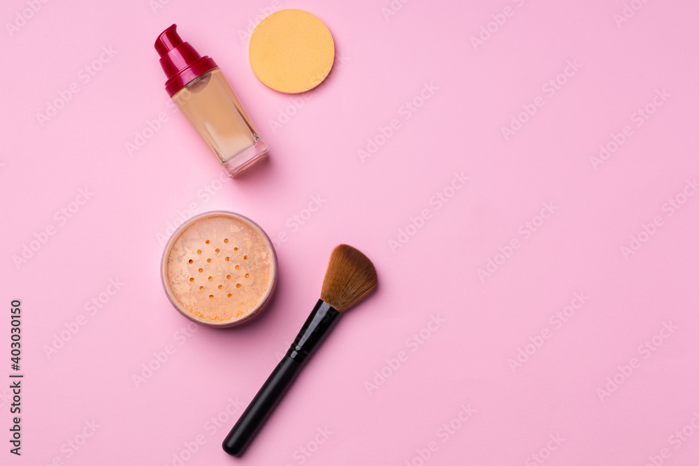 Complexion make up products and brush on pink background Complexion make up products and brush on pink background