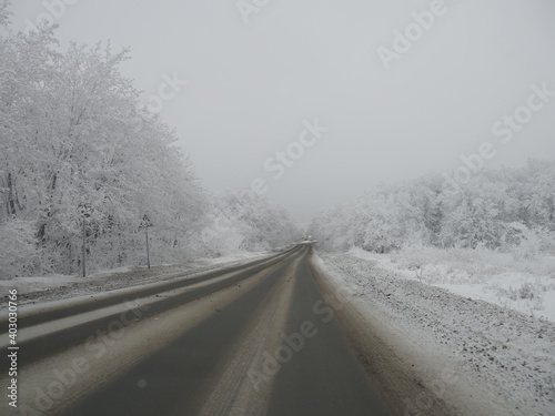 Empty snow covered road in winter landscape © Yulia