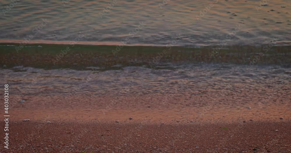 Calm sea water on sandy beach with footprints. Tilt down shot. Calm sea water on sandy beach with footprints. Tilt down shot.