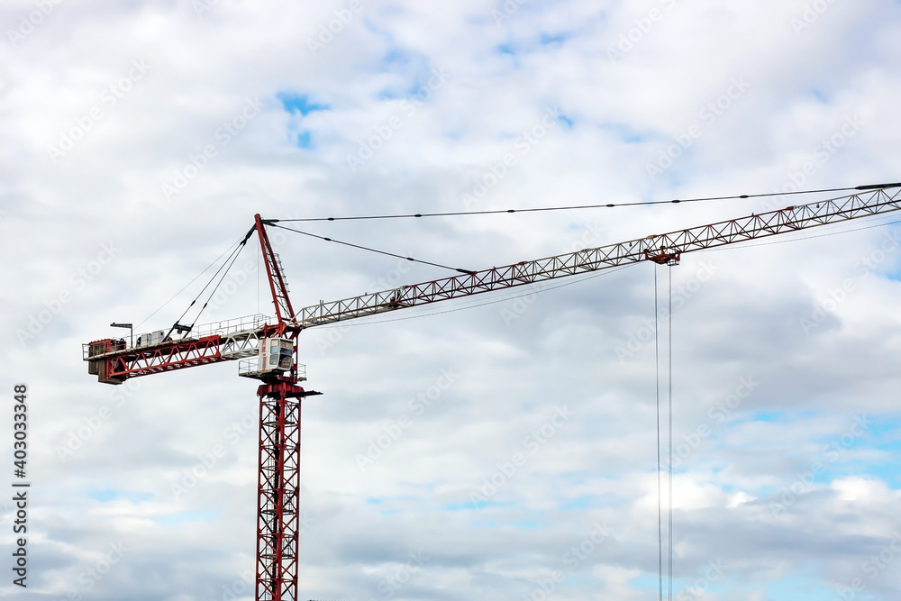 High crane for house building at construction site on blue sky background. High crane for house building at construction site on blue sky background.
