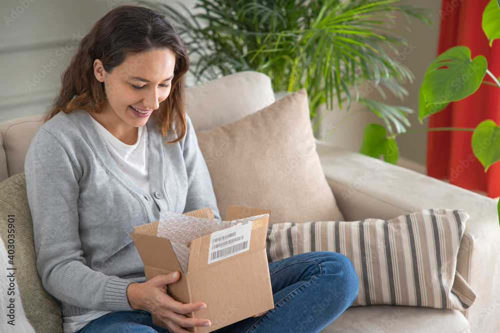 Woman opening personal online shopping parcel. Online shopping at home Woman opening personal online shopping parcel. Online shopping at home
