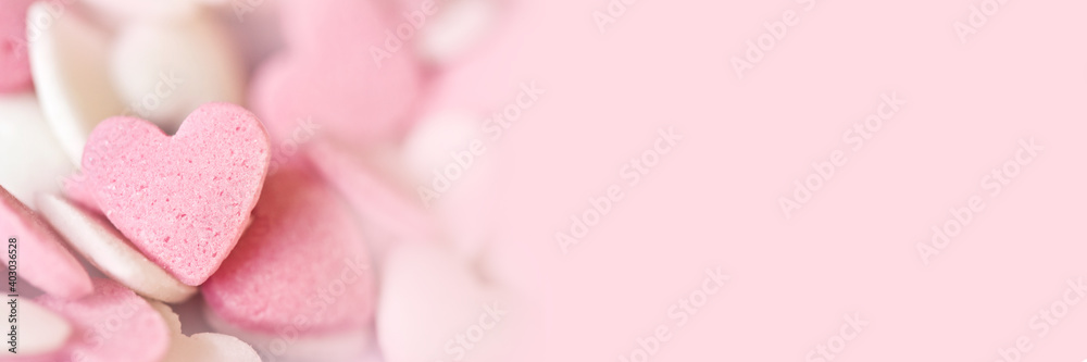 Pink sugar candy hearts on panoramic background with copy-space. Love, wedding or Valentines day web banner Pink sugar candy hearts on panoramic background with copy-space. Love, wedding or Valentines day web banner