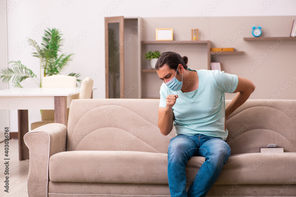 Fototapeta premium Young man coughing at home during pandemic
