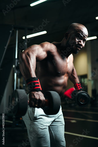 African american man is engaged in the gym performing strength training to build arm muscles