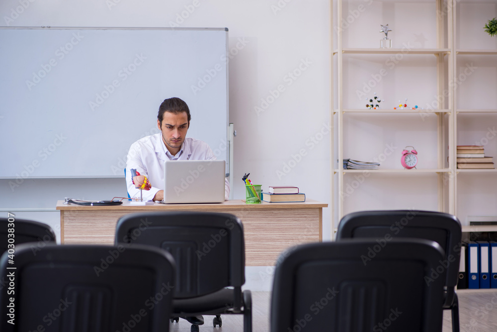 Fototapeta premium Young male doctor giving seminar in the classroom