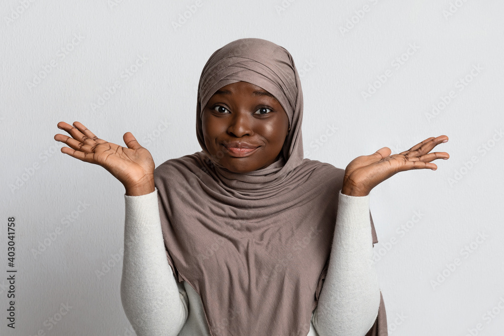 I Don't Know. Doubtful Black Muslim Lady Shrugging Shoulders And Spreading Arms - obrazy, fototapety, plakaty 