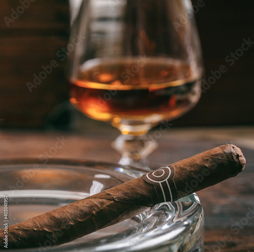 Cuban cigar in an ashtray on wooden desk