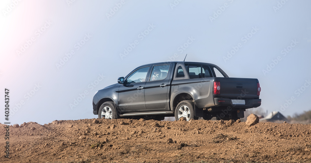 Fototapeta premium Pickup truck moves on a dirt road
