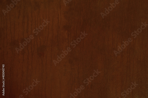 Mahogany colored wood panel background texture with delicate woodgrain pattern in a full frame view