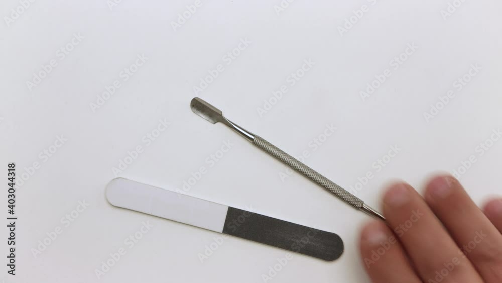 Close-up of a man's hand puts nail files, scraper and stick. Demonstration of tools for manicure. Items for work on a light surface. Professional hand care. Isolated video on a white background. Close-up of a man's hand puts nail files, scraper and stick. Demonstration of tools for manicure. Items for work on a light surface. Professional hand care. Isolated video on a white background.