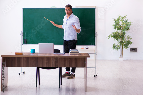 Fotografía Young male teacher in front of blackboard