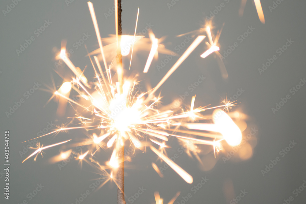 Obraz premium Sparkler lit burning down on a gray background 