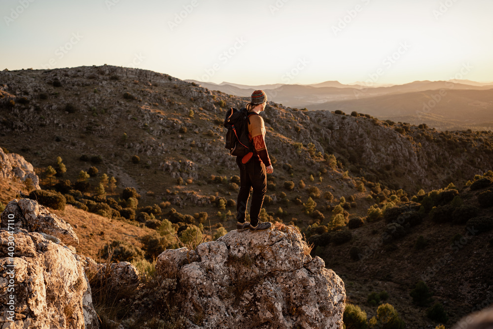 Man  mountains at sunset, concept of adventure and trekking