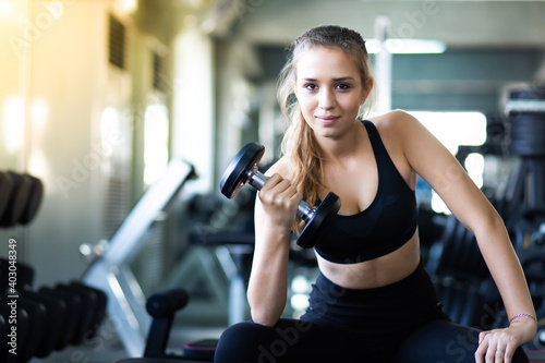 Exercising, Gym, fitness Women concept. athletic young woman doing a fitness workout with dumbbells at indoor gym © NVB Stocker