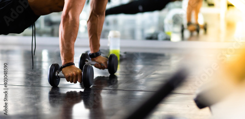 handsome man doing push ups exercise with one hand in fitness gym