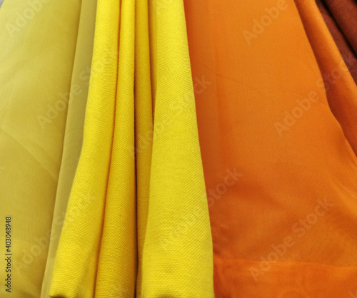 Detailed close up view on samples of cloth and fabrics in different colors found at a fabrics market. selective focus,