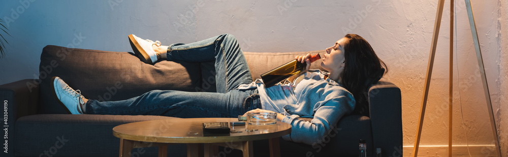 alcoholic woman drinking wine from bottle while lying on sofa, banner alcoholic woman drinking wine from bottle while lying on sofa, banner