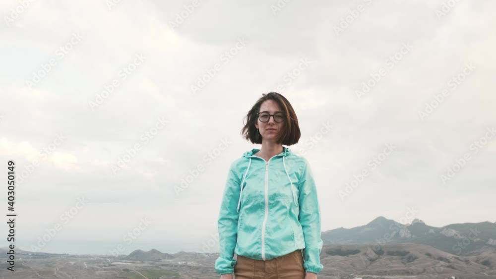 Beautiful traveler young woman wearing in blue jacket posing high over mountain valley in autumn. Beautiful traveler young woman wearing in blue jacket posing high over mountain valley in autumn.