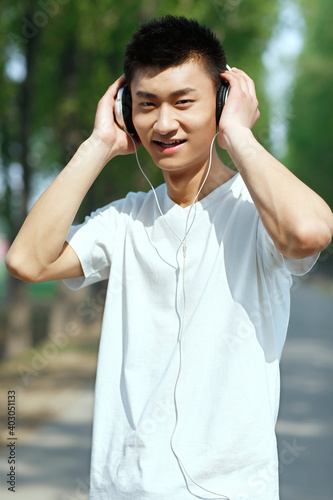 A young man listening music in the park