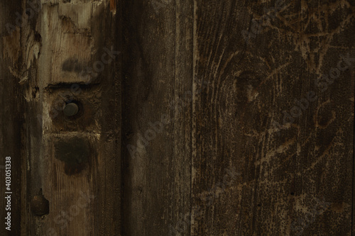 Background texture of an old weathered wood on wooden panel with a bolt to the side in a full frame view