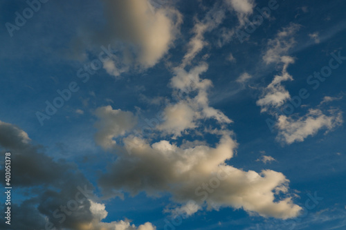 Blue deep sky with a few clouds illuminated by the setting sun. © Trik