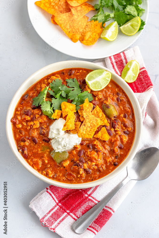 Mexican Chilli with Minced Meat Garnished with Savory Cream, Lemon and Cimantro Vertical Photo
