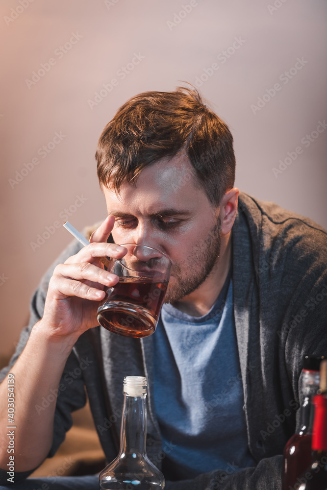 lonely man drinking whiskey while sitting at home alone lonely man drinking whiskey while sitting at home alone