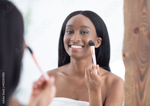 Woman get ready for work  does morning routine nude makeup  putting blush in bathroom at home