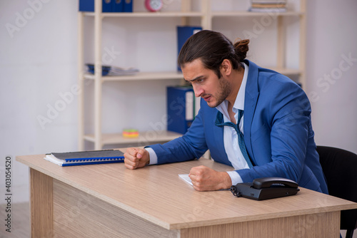 Young male employee and too much work in the office