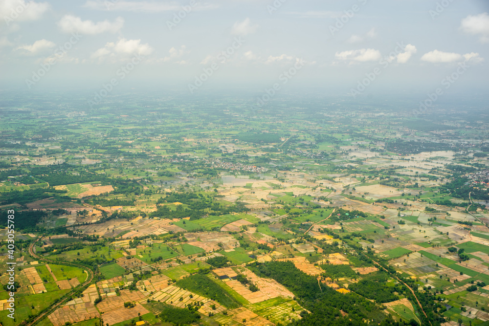 Aerial view from the top of meadow and abundant rice fields with clear cloud in summer