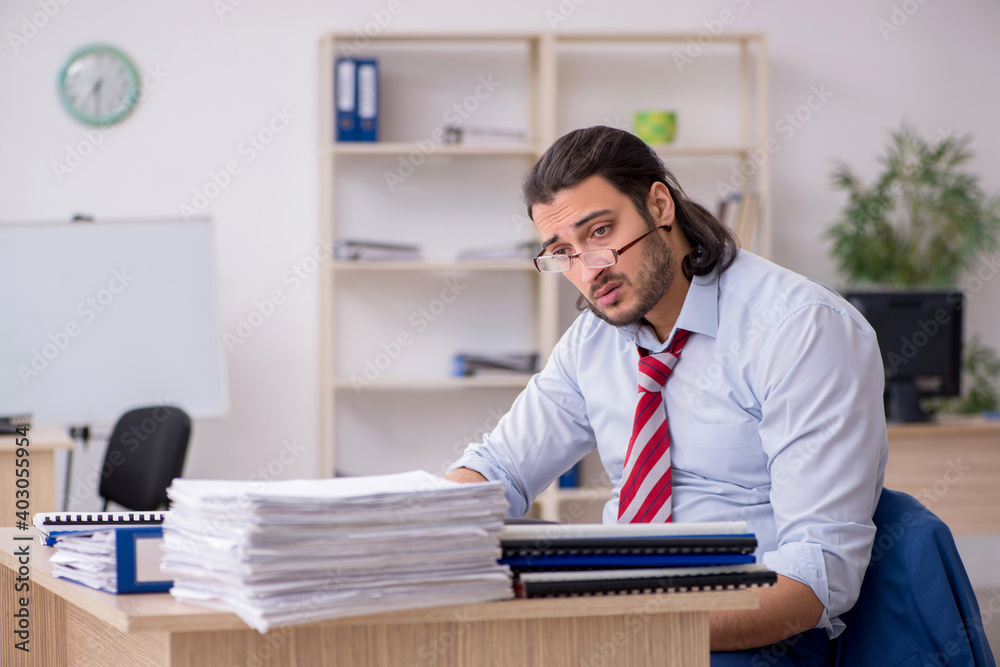Young male employee unhappy with excessive work Young male employee unhappy with excessive work