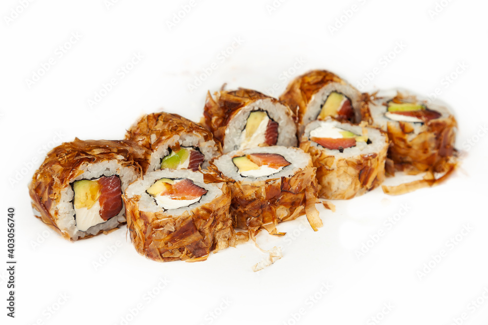 Sushi roll Bonito with smoked salmon on a white background, ingredients smoked salmon, cream cheese, avocado, tuna chips, rice, nori. Traditional Japanese food. For the restaurant menu Sushi roll Bonito with smoked salmon on a white background, ingredients smoked salmon, cream cheese, avocado, tuna chips, rice, nori. Traditional Japanese food. For the restaurant menu