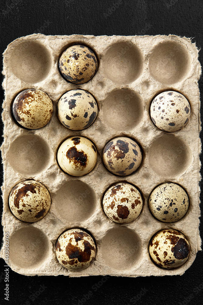 Quail eggs in the cardboard packing on the grey scratched table. Quail eggs in the cardboard packing on the grey scratched table.