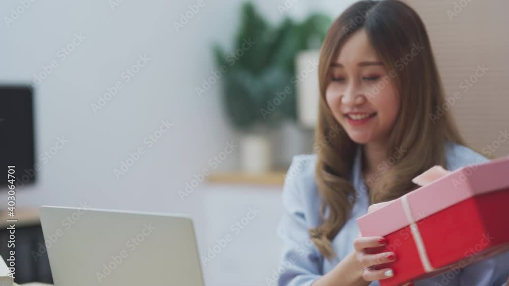 Young teenage girl feeling excited and happy talking with her boyfriend by using laptop while receive valentine and birthday present giftbox, new normal for online dating Young teenage girl feeling excited and happy talking with her boyfriend by using laptop while receive valentine and birthday present giftbox, new normal for online dating