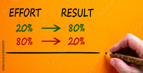 80 on 20 rule symbol. Male hand with pencil. Words 'effort, result'. Beautiful orange background, copy space. Business and 80 on 20 rule concept.