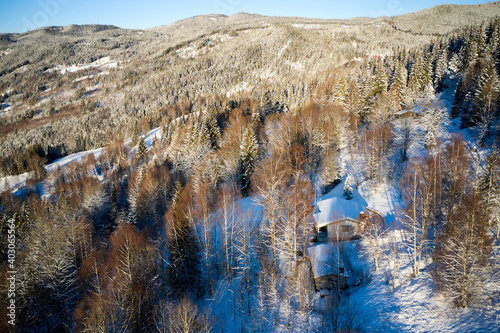 Drone photo from winter land Norway, Gol, Hallingdal. Shot in the cold in January in the blue hours early morning. Sun is rising and the frozen landscape is thawing.  photo