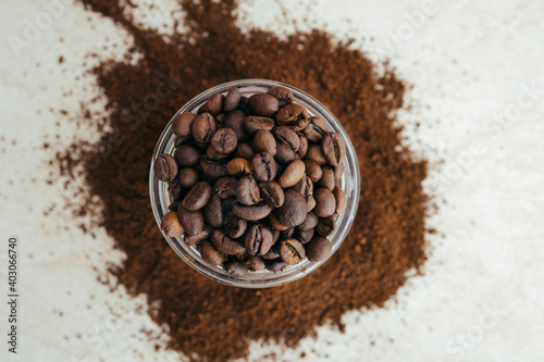 Freshly roasted coffee beans in a glass vessel top view, place for text