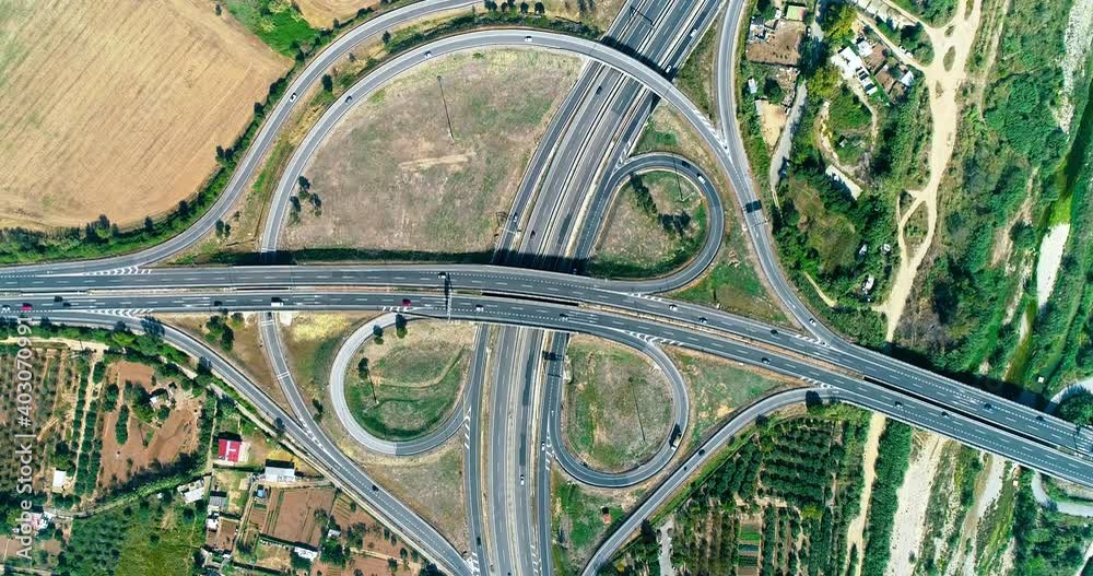 Beautiful interchange in Spain, with busy urban traffic. This is countryside all around the roads - aerial view with a drone 4K Beautiful interchange in Spain, with busy urban traffic. This is countryside all around the roads - aerial view with a drone 4K