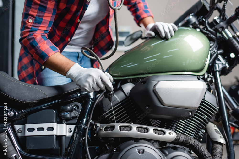 partial view of mechanic making diagnostics of motorbike engine with stethoscope partial view of mechanic making diagnostics of motorbike engine with stethoscope