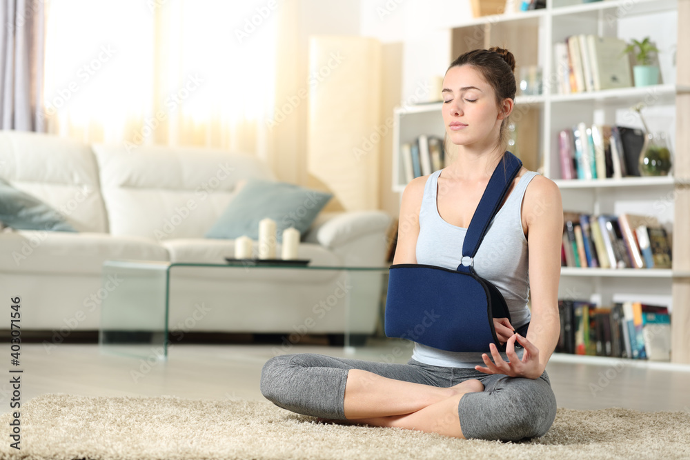 Disabled woman with a sling practicing yoga exercise