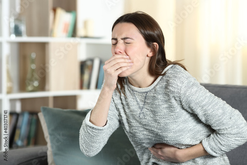 Woman with a stomach ache about to vomit at home photo