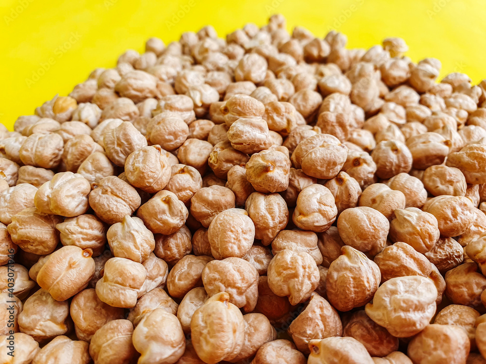 beans. Uncooked dried chickpeas on yellow background. Heap of legume chickpeas background beans. Uncooked dried chickpeas on yellow background. Heap of legume chickpeas background