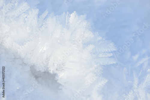 Hoarfrost background texture. Fresh ice and snow winter backdrop with snowflakes and mounds. Seasonal wallpaper. Frozen water geometrical shapes and figures. Cold weather atmospheric precipitation. © Сyrustr