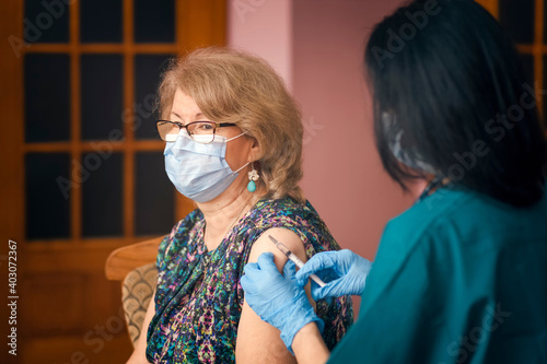 Doctor giving Covid vaccine to senior woman