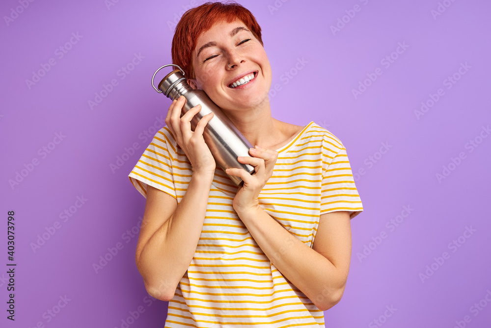 woman with thermos isolated on purple background, young female in casual wear shine with happiness, smile at camera woman with thermos isolated on purple background, young female in casual wear shine with happiness, smile at camera