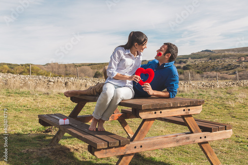 Young couple Hugging, kissing and enjoying spending time together while celebrating Saint Valentine's Day in the countryside. Love san valentin and Relationship concept.