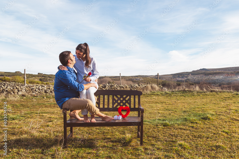 Young couple Hugging, kissing and enjoying spending time together while celebrating Saint Valentine's Day in the countryside. Love san valentin and Relationship concept. Young couple Hugging, kissing and enjoying spending time together while celebrating Saint Valentine's Day in the countryside. Love san valentin and Relationship concept.