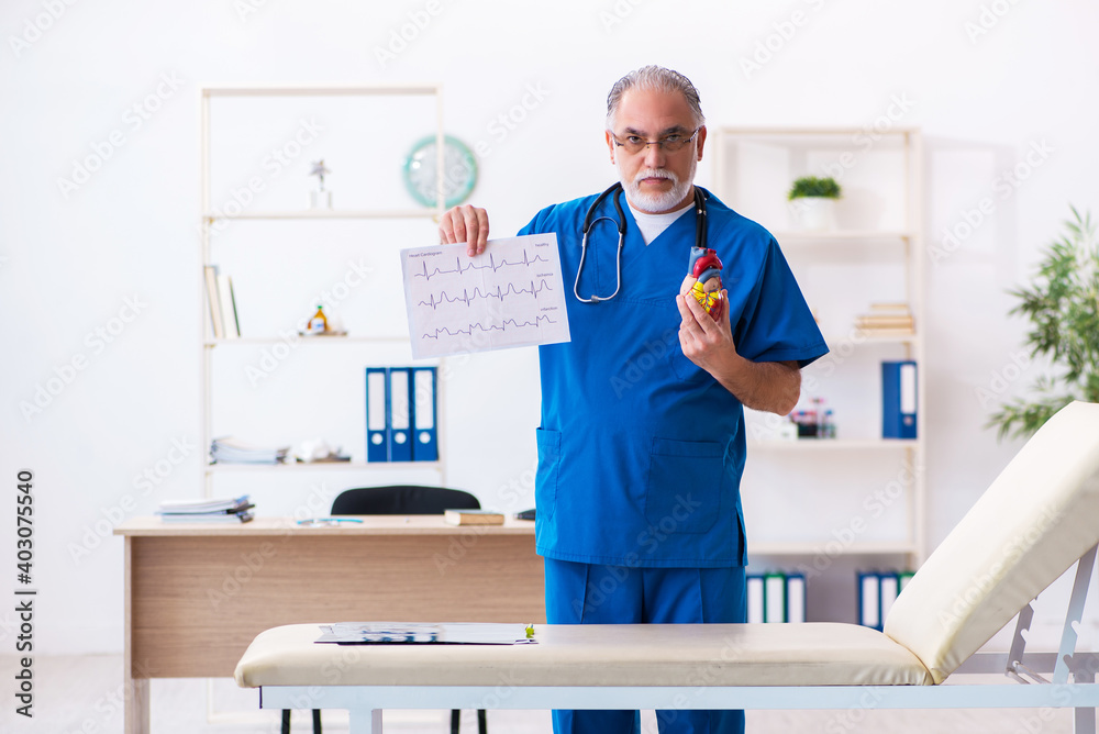 Old male doctor cardiologist looking electrocardiogram Old male doctor cardiologist looking electrocardiogram