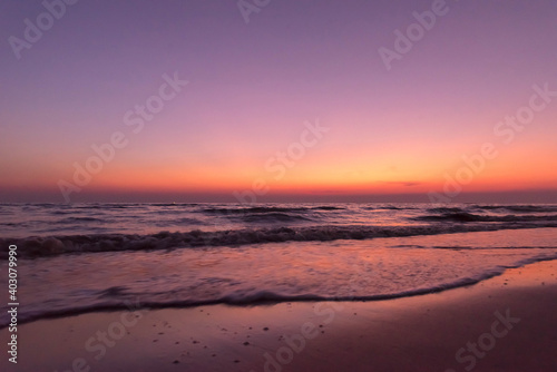 Nature in twilight period which including of sunrise over the sea and the nice beach. Summer beach with blue water and purple sky at the sunset. © czchampz