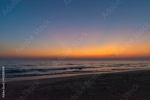 Nature in twilight period which including of sunrise over the sea and the nice beach. Summer beach with blue water and purple sky at the sunset.